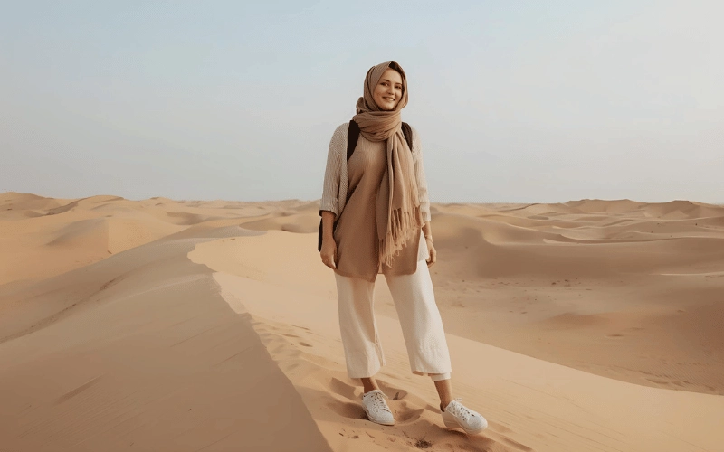 بانوی گردشگر در بیابان دبی با لباس مناسب، روسری سبک و کفش بسته